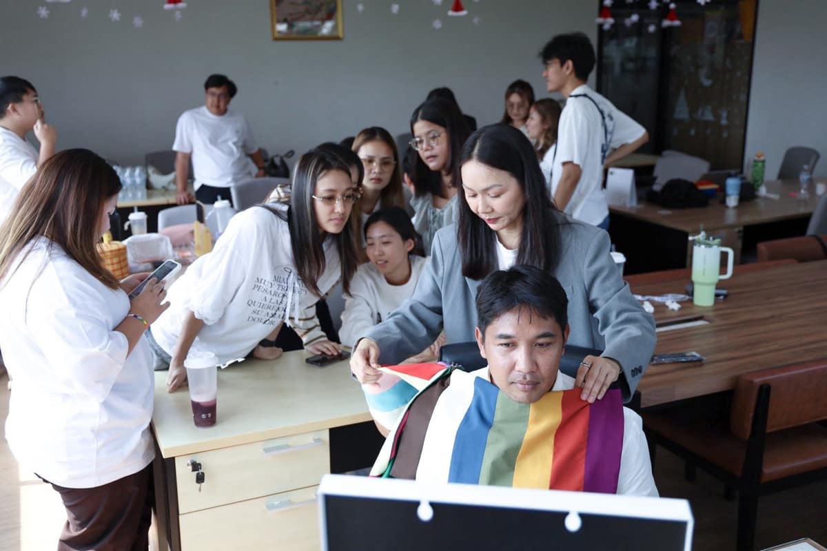 ทาบผ้าสีให้พนักงานทีละคน เพื่อนร่วมงานดูอยู่รอบๆ