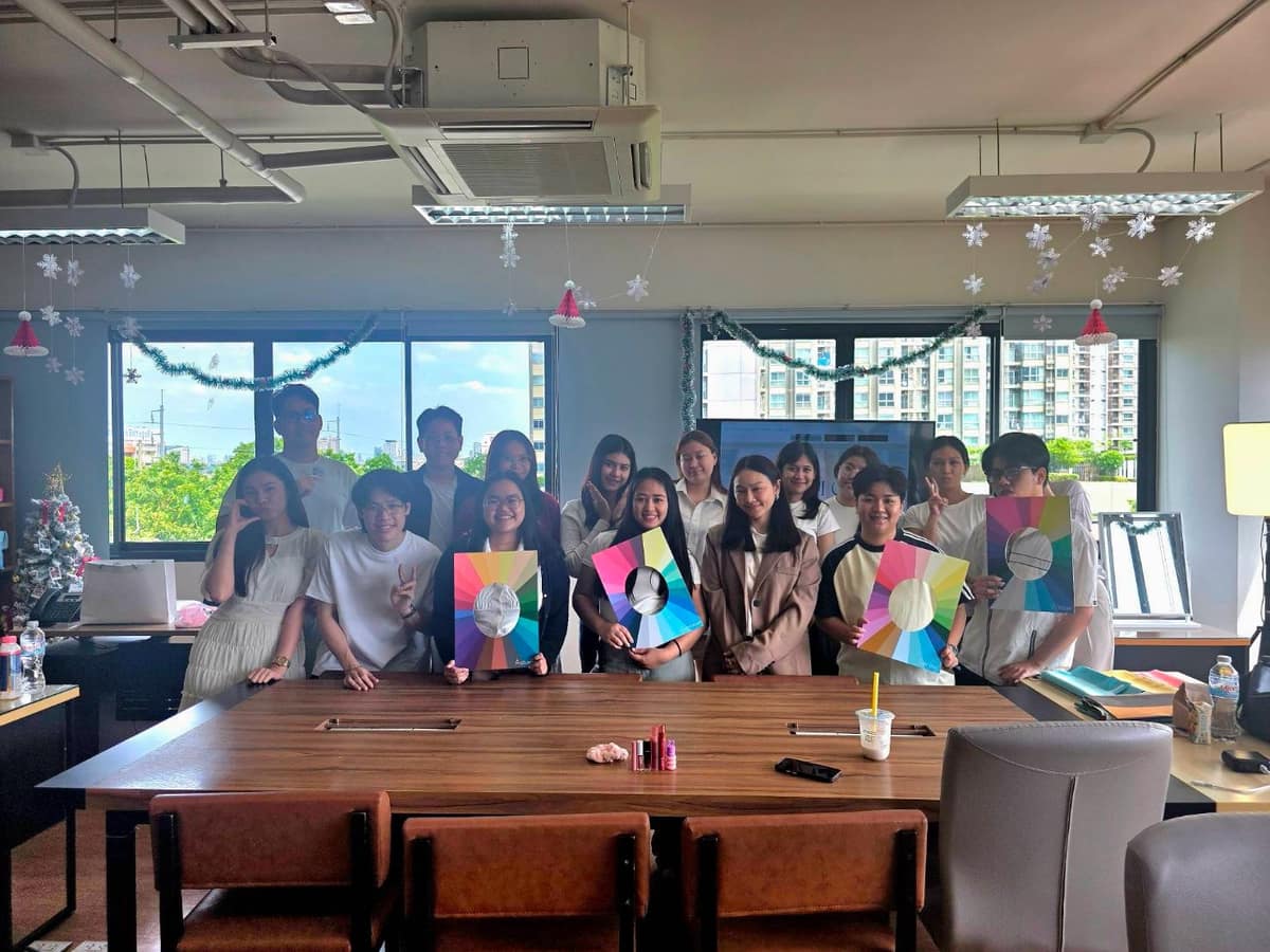 พนักงานถือบอร์ดกลุ่มสีหลังจบ workshop ในออฟฟิศ